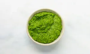 Eine Schüssel mit leuchtend grüner Salsa verde, die frisch und würzig aussieht.
