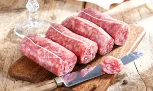 Frische Salsiccia-Würste liegen auf einem Holzbrett. Die korrekte Salsiccia Aussprache ist wichtig für den authentischen Genuss.