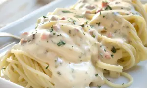 Spaghetti mit cremiger Carbonara-Sauce, garniert mit Petersilie. Ein köstliches Rezept für Carbonara.