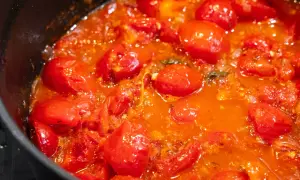 Frische Tomaten köcheln in einer Pfanne zu einer aromatischen Tomatensauce.