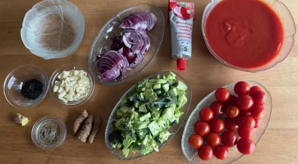 Zutaten für ein Gericht: Kirschtomaten, Brokkoli, Zwiebeln, Knoblauch, Ingwer, Gewürze und Tomatenmark mit viel Lycopin.