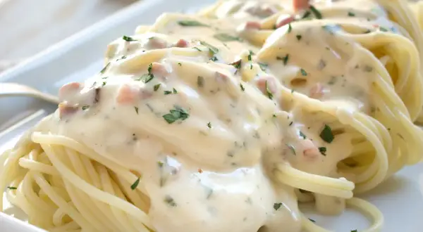 Spaghetti mit cremiger Carbonara-Sauce, garniert mit Petersilie. Ein köstliches Rezept für Carbonara.