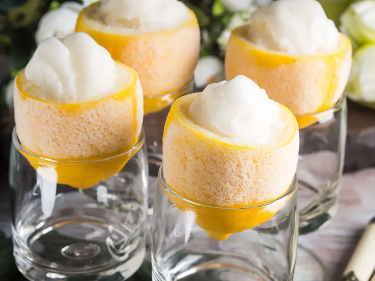 Erfrischendes Sorbetto al limone, serviert in ausgehöhlten Zitronen, die in Gläsern stehen.