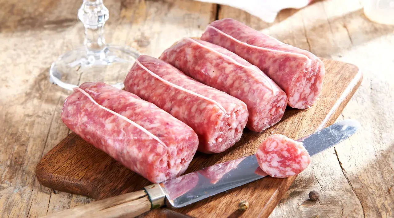 Frische Salsiccia-Würste liegen auf einem Holzbrett. Die korrekte Salsiccia Aussprache ist wichtig für den authentischen Genuss.