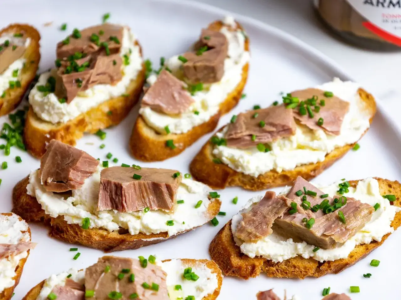Knusprige Brotscheiben mit cremigem Frischkäse und saftigen Thunfischstücken, garniert mit Schnittlauch. Ein köstlicher italienischer Thunfischbrotaufstrich.